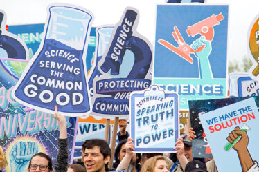 Photo from the March for Science in Washington D.C. showing smiling people holding pro-science signs.