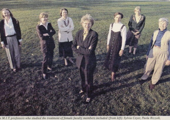 Seven MIT faculty pose with Killian Court in background