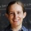 Tracy Slatyer poses in front of blackboard covered in physics equations